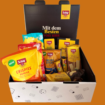 Eine offene Schachtel von schär mit vielen Tüten, verpackten waffeln, Crispies und Riegel