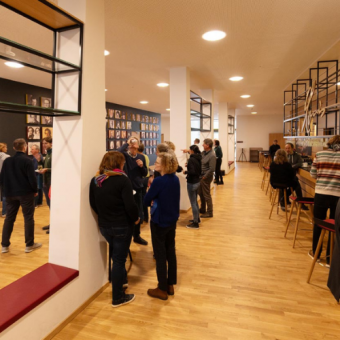 Bar und Loungebereich - Menschen stehn herum und unterhalten sich