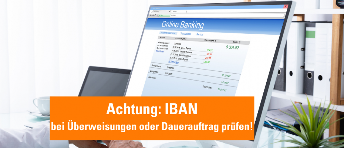 Computer mit Display für Online Banking und orangener Hinweis: Neue IBAN- bei Überweisungen und Dauerauftrag prüfen!
