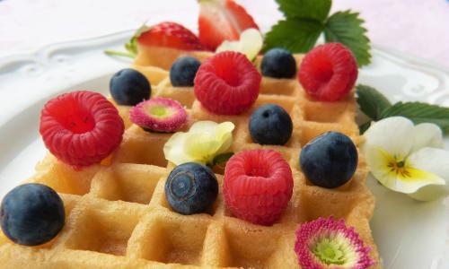 Belgische glutenfreie Waffel Belgische glutenfreie Waffel mit Beeren und Blüten