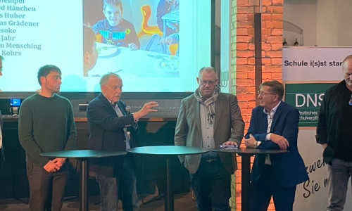 Mehrere Redner vor einem Bildschirm, der ein Kind zeigt beim Kongress für Schulverpflegung